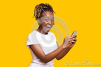 Excited black woman using mobile phone, got new nice app Stock Photo