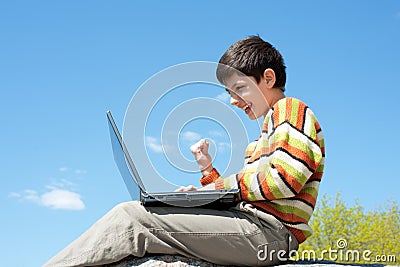 Excited boy playing with wireless laptop Stock Photo