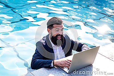 Excited businessman in suit with laptop in swimming pool. Funny business man, crazy comic business concept. Stock Photo