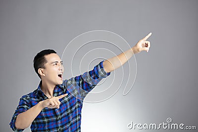 Casual dressed young man pointing right Stock Photo