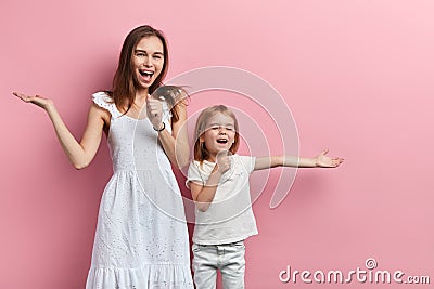 Excited cheerful happy mother and little daughter enjoying singing Stock Photo