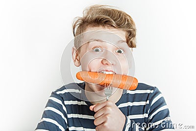 Excited child biting into large carrot Stock Photo