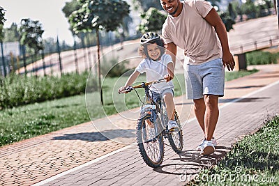 Excited child learning cycle with a help of his dad Stock Photo