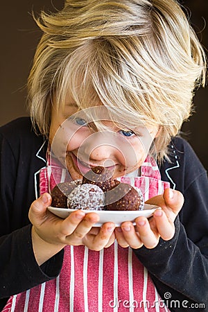 Excited child showing homemade chocolate balls Stock Photo