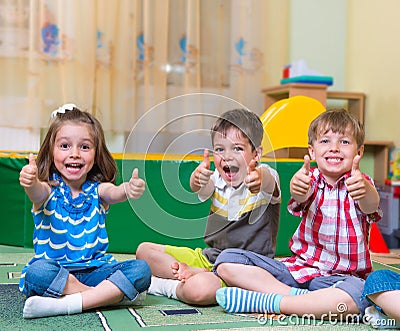 Excited children holding thumbs up Stock Photo