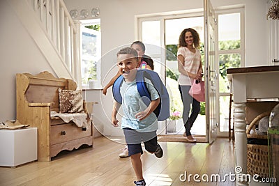 Excited Children Returning Home From School With Mother Stock Photo