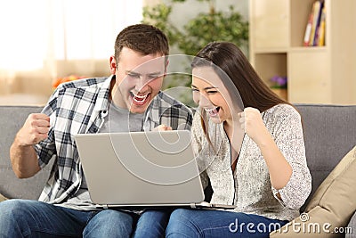 Excited couple reading news on line Stock Photo