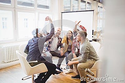 Excited creative business people giving high-five Stock Photo