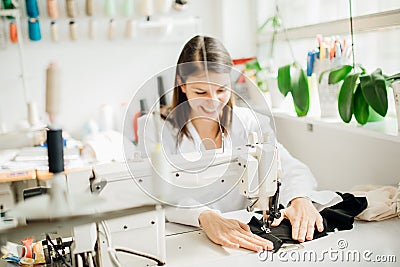 Excited creative tailor working on sewing machine.Handmade protective cotton masks making.DIY project,learning to sew on sewing Stock Photo