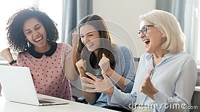 Excited diverse female employees feel euphoric winning online Stock Photo