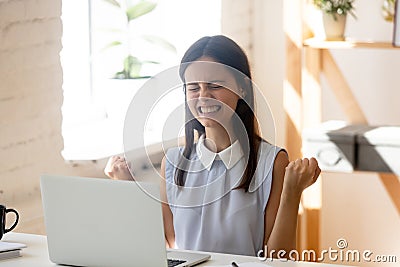 Excited euphoric millennial woman enjoy moment of victory Stock Photo