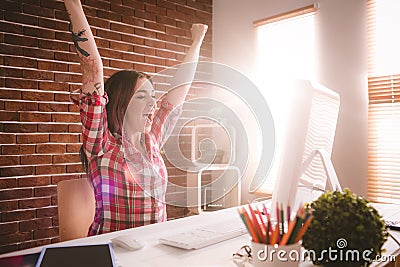 Excited executive using desktop computer in office Stock Photo