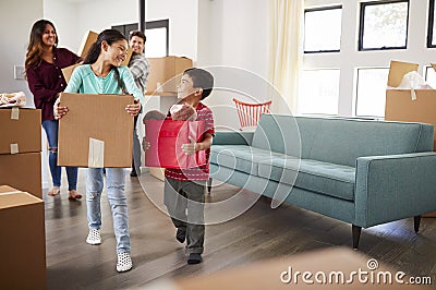 Excited Family Carrying Boxes Into New Home On Moving Day Stock Photo