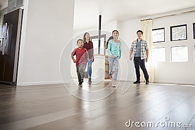 Excited Family Exploring New Home On Moving Day Stock Photo