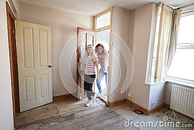 Excited Female Couple Opening Front Door Of New Home Stock Photo