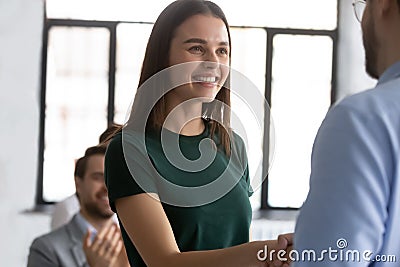 Excited female employee feeling proud shaking leader hand receiving recognition Stock Photo