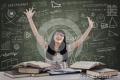 Excited female student in class with books Stock Photo