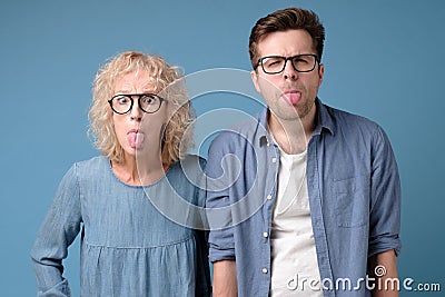 Excited funky funny comic cheerful guy and lady making stick tongue out. Stock Photo