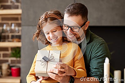 Excited girl daughter receiving gift box from young loving father on holiday Stock Photo