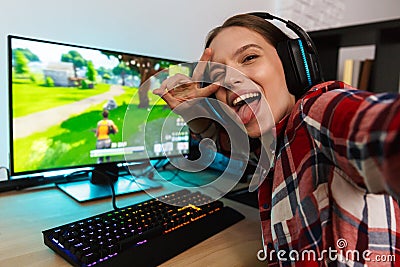 Excited girl gamer sitting at the table, playing online games Stock Photo