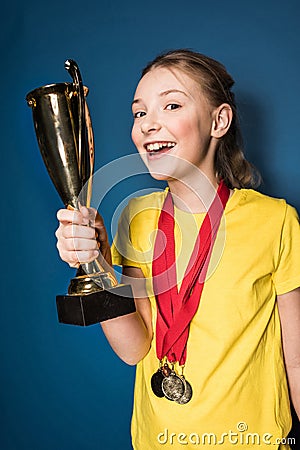 Excited girl with medals and trophy cup Stock Photo