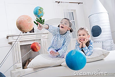 Excited girls looking at planets models Stock Photo