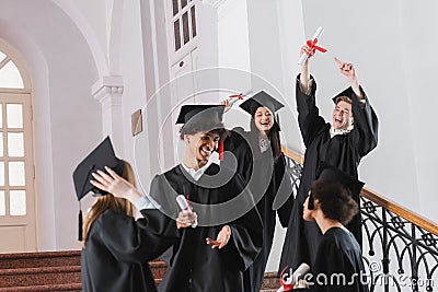 Excited graduate pointing at diploma near Stock Photo