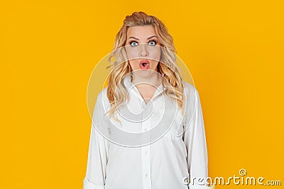 An excited woman with a surprised open mouth looks fearfully into the camera, expressing amazement from the shock Stock Photo