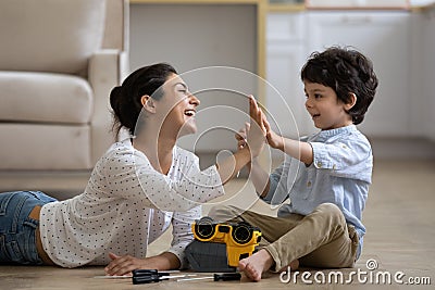 Excited Indian mother with 5s son repairing toy car Stock Photo