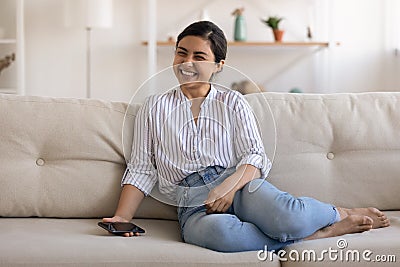Excited Indian young woman using smartphone, making easy internet payment Stock Photo