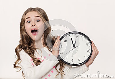 Excited little girl with clock at white background Stock Photo