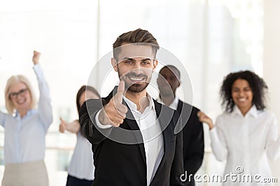 Excited male employee show thumbs up satisfied with company Stock Photo
