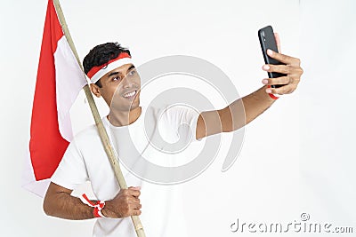 Excited male holding indonesian flag and taking selfie Stock Photo