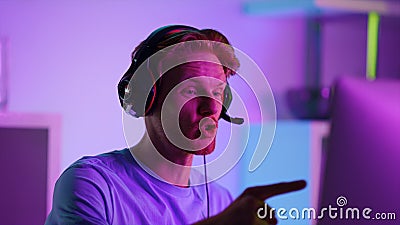 Excited man celebrating cyber tournament success closeup. Happy gamer in neon Stock Photo