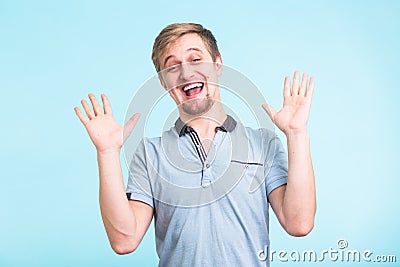 Excited man exclaimed in happiness, gestures actively, expressed great surprisement, over blue background Stock Photo