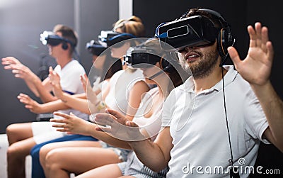 Excited man experiencing with friends virtual reality Stock Photo