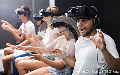 Excited man experiencing with friends virtual reality Stock Photo