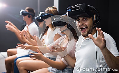 Excited man experiencing with friends virtual reality Stock Photo