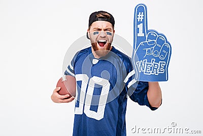 Excited man fan wearing fan glove holding rugby ball. Stock Photo