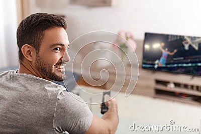 Excited man switch TV to basketball Stock Photo