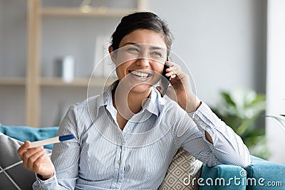Excited pregnant indian woman holding pregnancy test calling husband Stock Photo