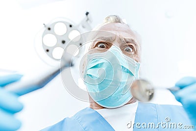 Excited professional dentist in medical mask holding dental tools Stock Photo