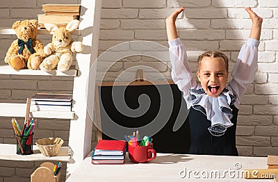 Excited school girl in classroom at school. Amazed kids education and study concept. Stock Photo