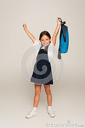excited schoolkid with blue backpack showing Stock Photo