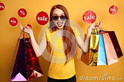 Excited shopping woman in sunglasses expresses joy Stock Photo