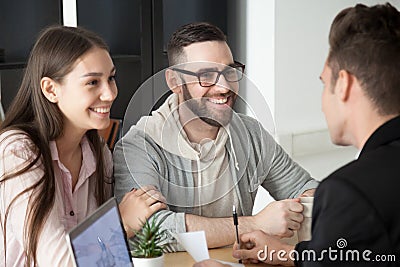 Excited smiling millennial couple discussing mortgage loan inves Stock Photo