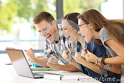 Excited students reading good news in a classroom Stock Photo