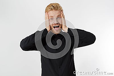 Excited surprised shock young shouting man isolated on gray background. Happy Redhead guy with red beard in black stylish shirt. Stock Photo