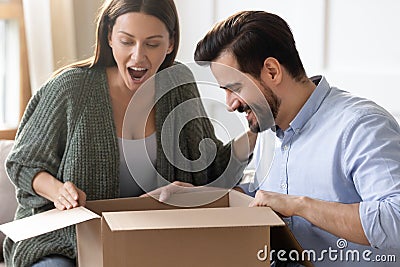 Excited surprised woman looking into cardboard box, receive parcel Stock Photo