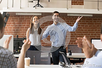 Excited team leader congratulating employee with promotion while Stock Photo